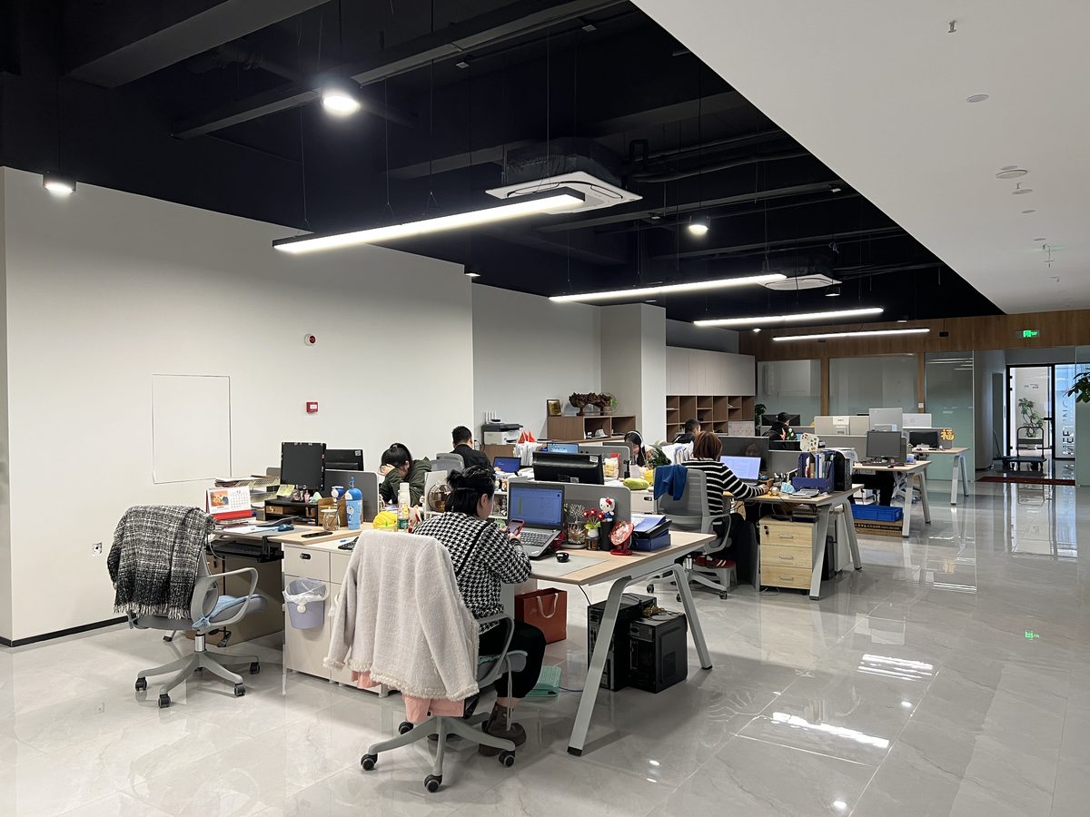 大开间工区:黑顶灯带配成排浅色工位
